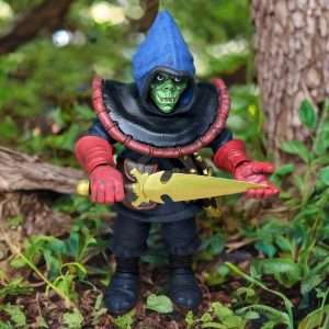 A detailed action figure of Zarak from Dungeons and Dragons, featuring a green face, blue hood, and red gloves, holding a golden notched dagger outdoors.
